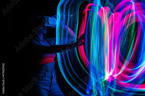 Metaverse digital Avatar, Metaverse Presence, digital technology, cyber world, virtual reality, futuristic lifestyle. Woman in VR glasses playing AR augmented reality NFT game with neon blur lines