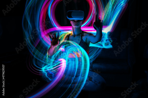 Metaverse digital Avatar, Metaverse Presence, digital technology, cyber world, virtual reality, futuristic lifestyle. Woman in VR glasses playing AR augmented reality NFT game with neon blur lines photo