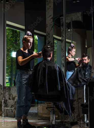hipster is a dark-haired caucasian appearance on a haircut in a barbershop, hairdressing