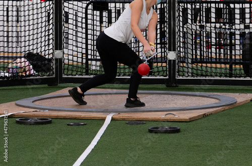 Girl throwing the weight indoors at a track meet photo