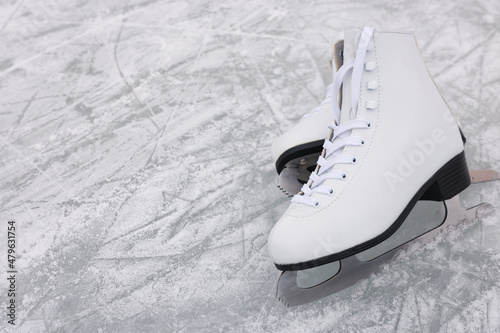Pair of figure skates on ice, space for text