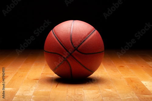 Basketball with spot lighting on hardwood maple basketball court floor © Daniel Thornberg