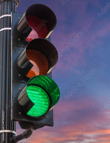 Concept of hope and positivity with a traffic signal on green set against a sunrise or sunset