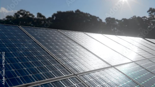 Off grid home solar cell system. Close up detail of photovoltaic panels charging with sun energy at clear sunny day with a green forest park on the background