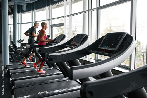 Senior couple running on treadmill in health club © Svitlana