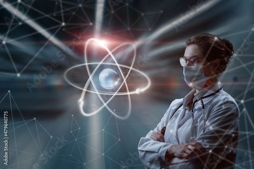 A woman in a mask in uniform looks at an atom on a blurred background.