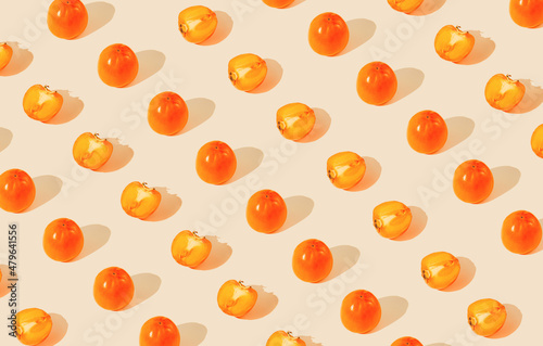 Fototapeta Naklejka Na Ścianę i Meble -  Creative pattern made of persimmon fruits on pastel background with sunlit. Healthy food concept. Minimal style.