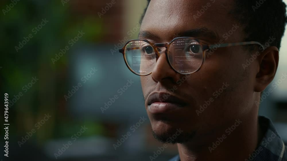 Portrait of software developer with vfx of running code reflected in glasses reading algorithm working focused looking at computer screen. Focus on moving eyes of coder typing in front of monitor. Portrait of software developer with vfx of running code reflected in glasses reading algorithm working focused looking at computer screen. Focus on moving eyes of coder typing in front of monitor.