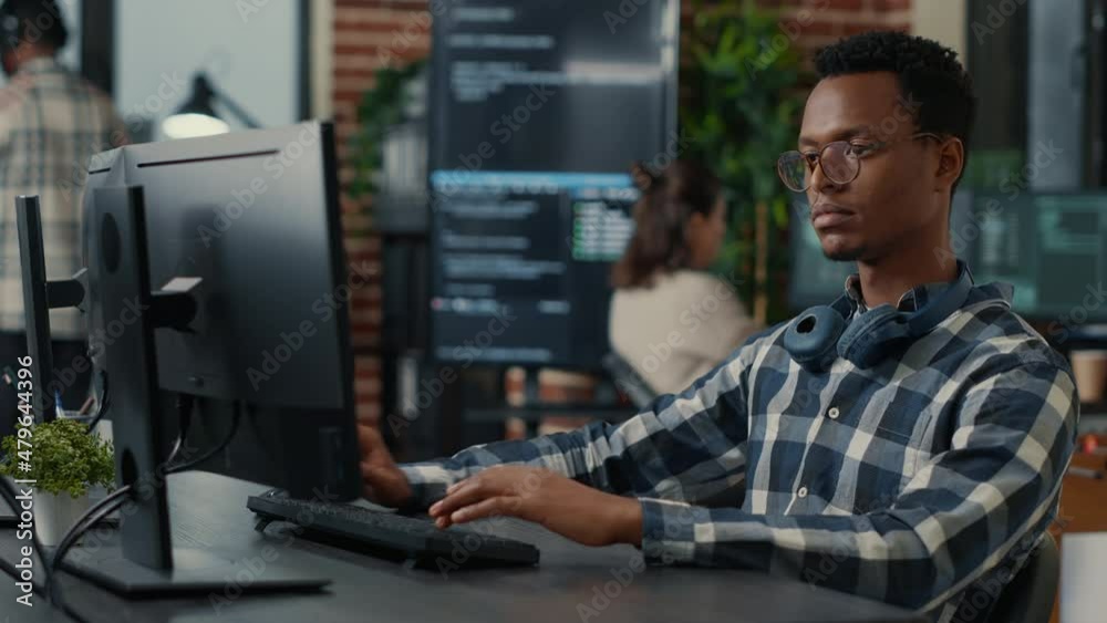 Portrait of software engineer writing code arranging glasses and being happy about parsing results. Smiling programer typing machine learning algorithm on keyboard innovating cyber security.
