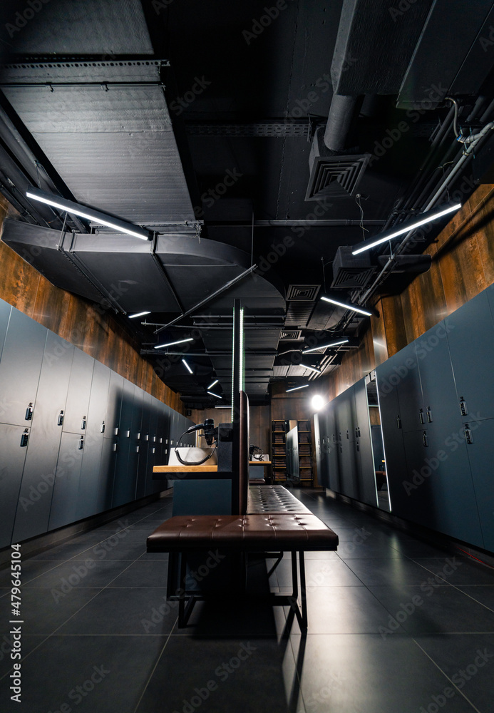 Wooden lockers with a luxury bench in a locker room with doors closed ...