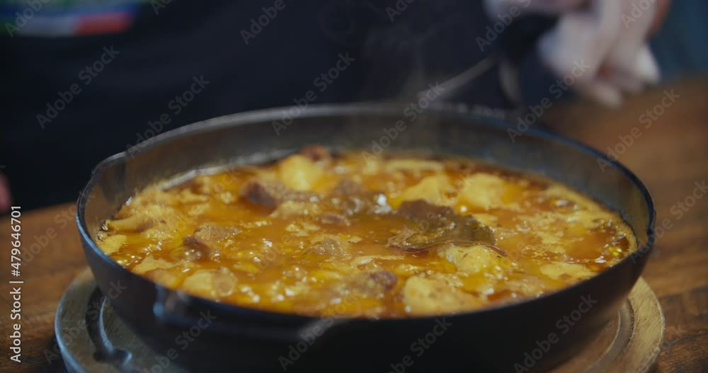 Pork Rillettes boiling in Cast Iron Pan out of Oven Pork Rillettes boiling in Cast Iron Pan out of Oven