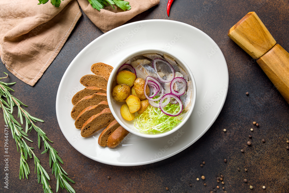 Herring with potatoes on dark brown concrete table top view Herring with potatoes on dark brown concrete table top view