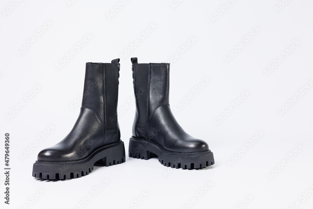 Women's shoes on a white background. Close-up of women's black leather chelsea boots on a white background. Shoes for the city. Fashion, design and footwear concept. Women's shoes on a white background. Close-up of women's black leather chelsea boots on a white background. Shoes for the city. Fashion, design and footwear concept.