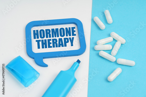 On the white and blue surface are a marker, tablets and a plate inside which the inscription - Hormone Therapy