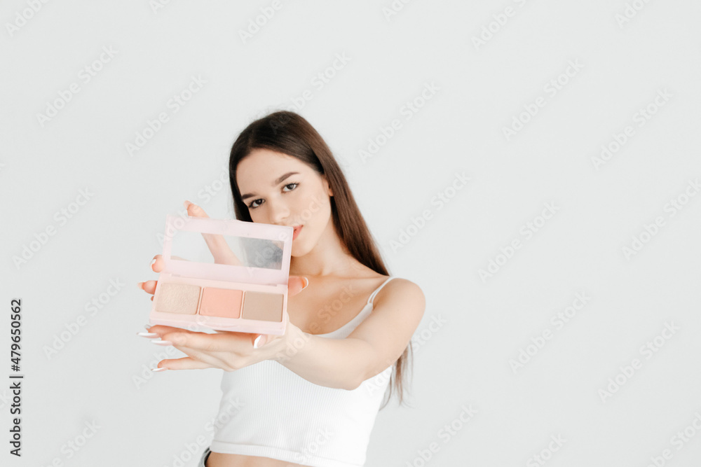 Portrait of beautiful girl showing a contouring palette with bronzer, highlighter and a blush, to the camera. The work of make up artist Portrait of beautiful girl showing a contouring palette with bronzer, highlighter and a blush, to the camera. The work of make up artist