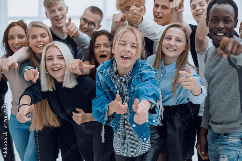 group of cheerful young people pointing at you