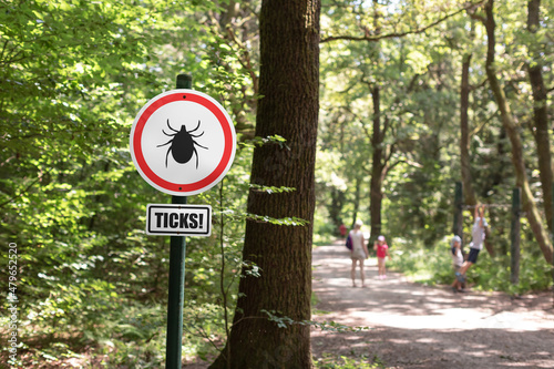 Tick insect warning sign in nature forest. Danger of Lyme disease, Borrelia and Meningitis. photo