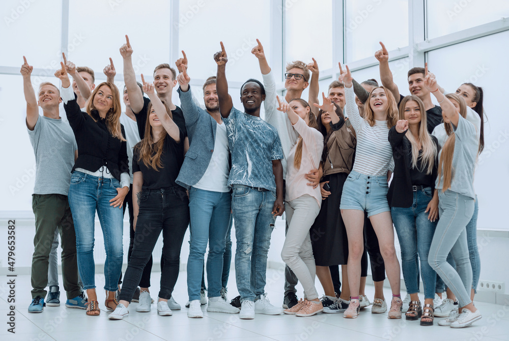 Fototapeta premium group of happy young people pointing upwards