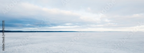 Frozen forest lake on a cloudy day. Dramatic sky after a blizzard. Onega, Karelia, Russia.Atmospheric winter landscape. Panoramic view. Nature, climate change, christmas vacations, eco tourism photo