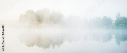Obraz na plátně Picturesque scenery of the forest lake in a thick white fog