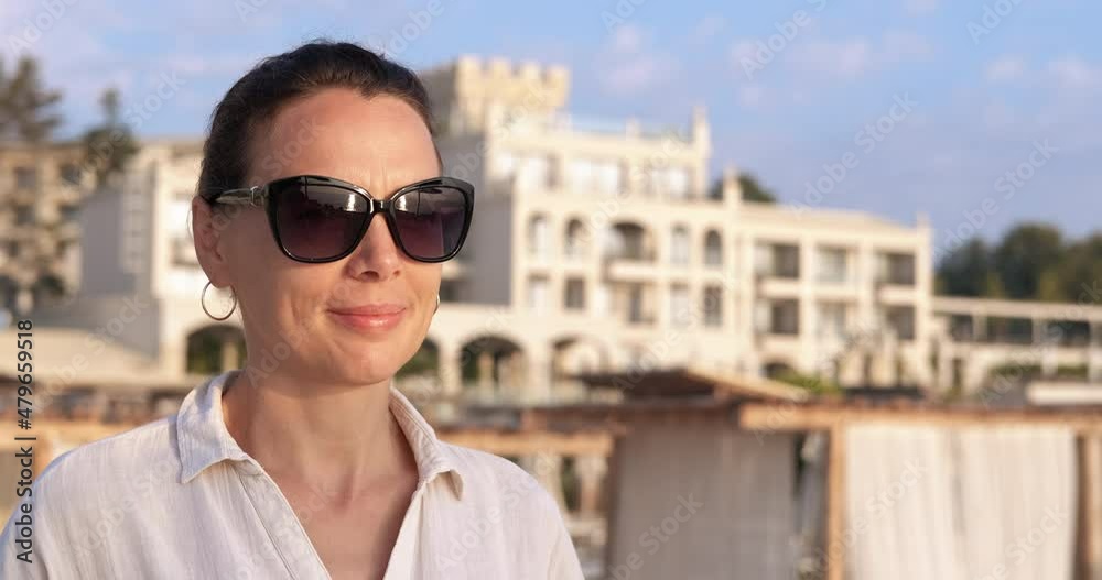 Woman enjoying sea shore life. A happy woman in sunglasses enjoy the sea shore in summer. Woman enjoying sea shore life. A happy woman in sunglasses enjoy the sea shore in summer.