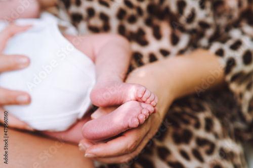 Baby feet in mother hands. Tiny Newborn Baby feet on female hands close up. Mom and her child. Care, Happy Family concept