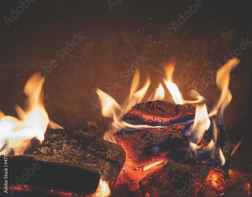 The fireplace is filled with burning wood. Safe fire at home. Fireplace flame in the night.