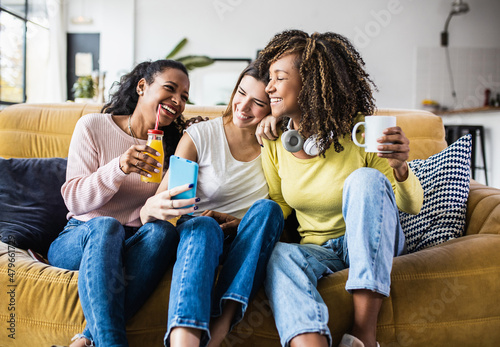 Obraz na plátne Cheerful multiracial female friends enjoying free time together at home - Three