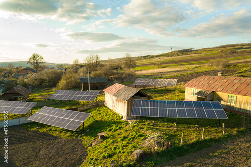 Aerial top down view of solar panels in green rural village yard.