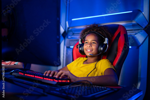 Professional gamer with headset playing or streaming online video games on computer. Children addicted to entertainment industry.