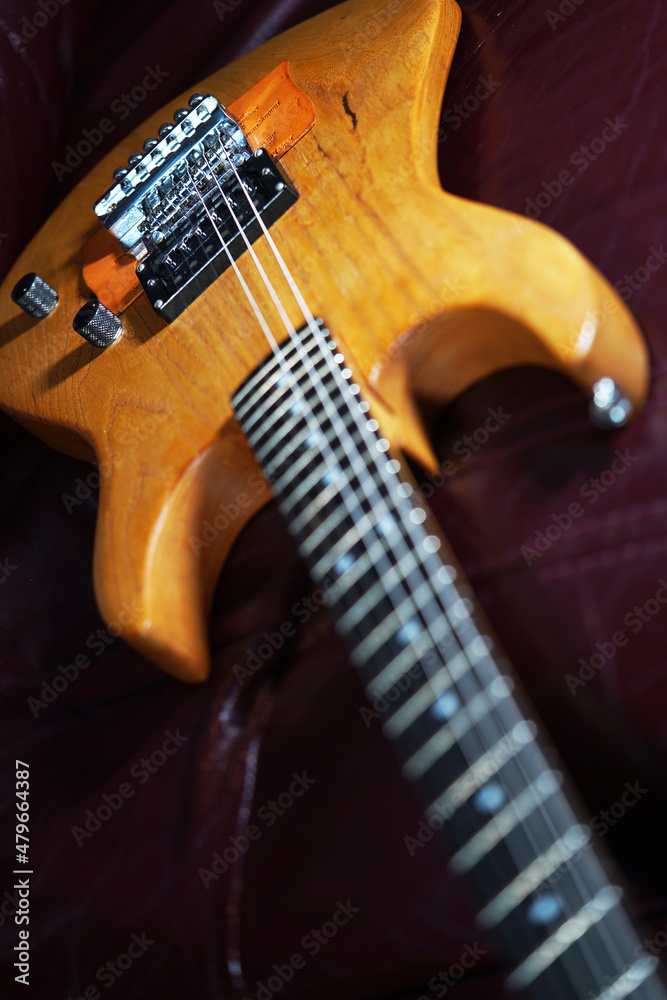Fototapeta premium Guitar wallpaper. Musical instrument. Performance. Art. Strings. Electric guitar closeup detail. Music. Play. Wooden vintage guitar. Ukulele 