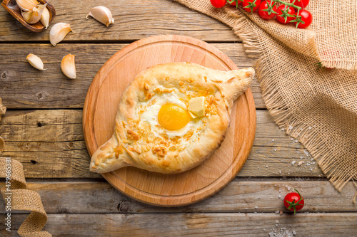 ajara Khachapuri with cheese, egg and butter, georgian kitchen on wooden table top view photo