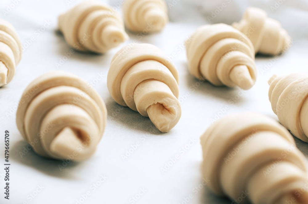 Semifinished croissant on a baking sheet. Puff pastry baking. Semifinished croissant on a baking sheet. Puff pastry baking.