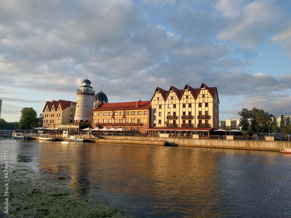Fototapeta premium The Fishing Village and lighthouse on the banks of Pregolya River at sunset light, Kaliningrad, Russia