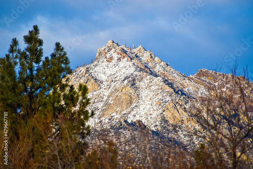 Stunning tall snow covered mountain peak on sunny blue sky day