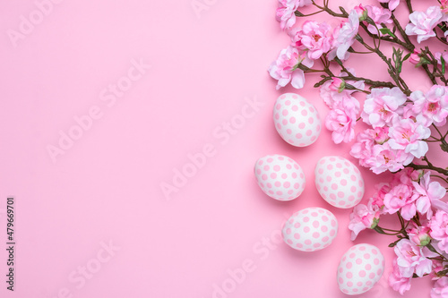 Easter template with paschal eggs and cherry blossom, greeting card with copy space, pastel pink background. Spring season. Christian tradition concept. Flat lay, mockup. Top view, space for text.