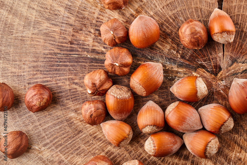 Heap of hazelnuts in shell isolated on wooden background Heap of hazelnuts in shell isolated on wooden background