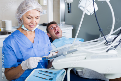 Female dentist with male patient in modern dentistry.