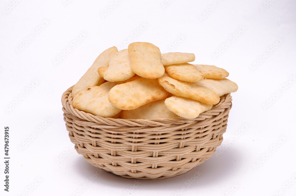 Spicy rice cracker in a bamboo bowl with isolated white background Spicy rice cracker in a bamboo bowl with isolated white background