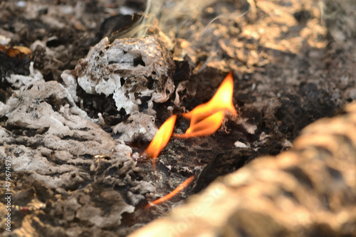 Wallpaper Mural Close-up of a defocused view of a smoldering fire. Blurred background. A small flame of a dying fire, smoke. Cozy warm atmosphere due to outdoor recreation by the fire, burning. Torontodigital.ca