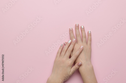 Hands of a girl with stylish winter makeup on a pastel background. Manicure. Flat lay.