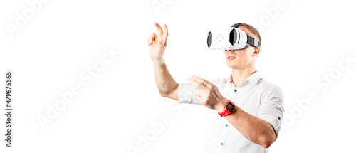 A successful man in a white vr helmet in a white shirt looking up on a white background. © Aboltin