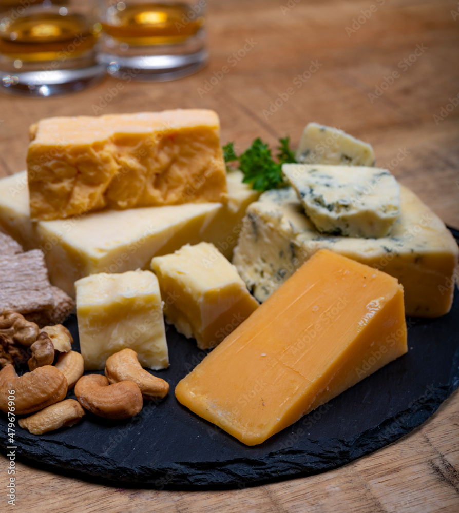 British drinks and food, glasses of Scotch whisky and cheeses collection, blue Stilton, Scottish coloured and English matured cheddar cheeses