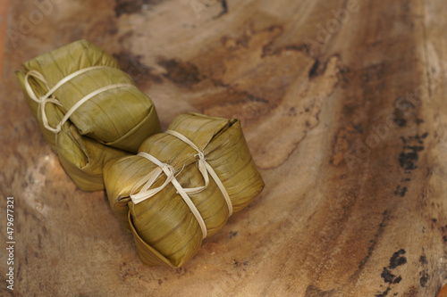 Thai dessert, sticky rice steamed with banana in banana leaf (Khao Tom Mad or Khao Tom Pad) at Thailand, Sticky rice steamed with banana isolated on white background, stacked with clipping path. photo