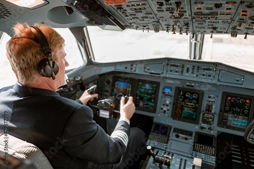 Fotografia Male pilot controlling airplane flight from cockpit