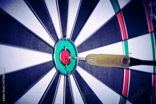 Concept achieving goal .Achieving goals in business and life.Dartboard with dart stuck right in center of target.