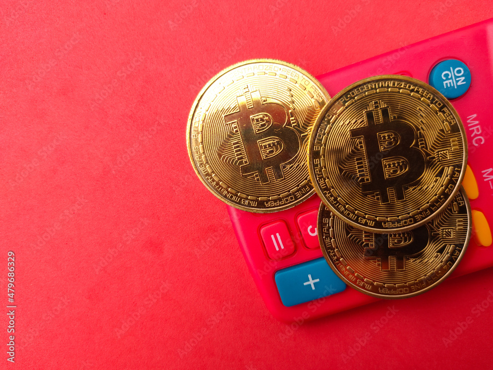 Top view golden bitcoin and calculator on red background with copy space. Top view golden bitcoin and calculator on red background with copy space.