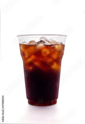 Soft drink with soda and ice cubes in plastic glass isolated on a white background.