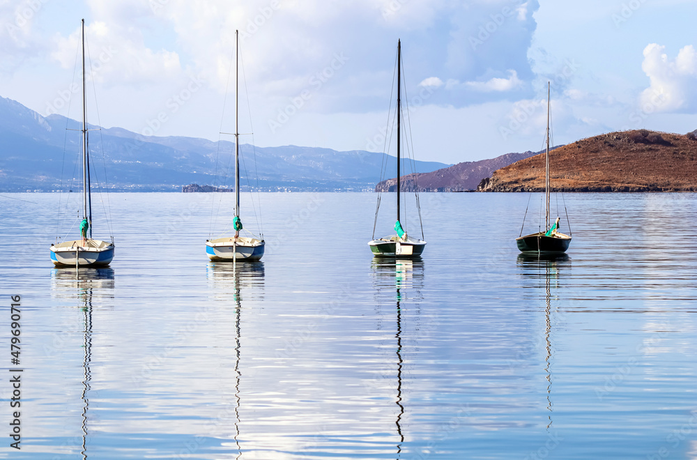 Sailboats in the blue sea against the backdrop of islands and mountains