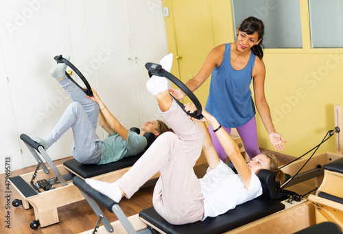 Teens training in pilates lessons led by a female trainer